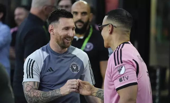 Inter Miami forward Lionel Messi, left, greets rapper Daddy Yankee, right, as he arrives to the field ahead of an MLS soccer match against the Colorado Rapids, Saturday, April 6, 2024, in Fort Lauderdale, Fla. (AP Photo/Rebecca Blackwell)