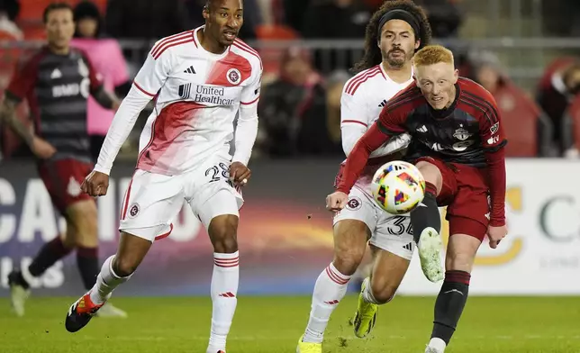 Toronto FC's Matty Longstaff, front right, moves the ball as New England Revolution's Mark-Anthony Kaye (28) and Ryan Spaulding (34) defend during second-half MLS soccer match action in Toronto, Saturday, April 20, 2024. (Frank Gunn/The Canadian Press via AP)