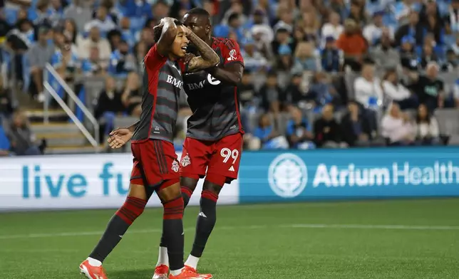 Toronto FC midfielder Jahkeele Marshall-Rutty, left, reacts to a missed shot as he is embraced by forward Prince Osei Owusu (99) during the second half of the team's MLS soccer match against Charlotte FC in Charlotte, N.C., Saturday, April 13, 2024. (AP Photo/Nell Redmond)