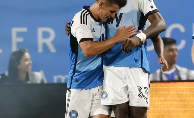 Charlotte FC forward Patrick Agyemang, right, hugs midfielder Ashley Westwood after scoring a second-half goal against Toronto FC in an MLS soccer match in Charlotte, N.C., Saturday, April 13, 2024. (AP Photo/Nell Redmond)