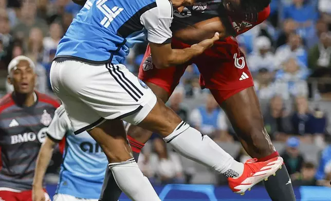 Toronto FC defender Aime Mabika, right, collides with Charlotte FC defender Jaylin Lindsey on a second-half corner kick during an MLS soccer match in Charlotte, N.C., Saturday, April 13, 2024. (AP Photo/Nell Redmond)