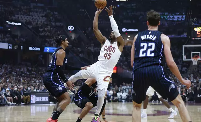 Cleveland Cavaliers guard Donovan Mitchell (45) shoots against Orlando Magic guard Gary Harris, left, and forward Franz Wagner (22) during the first half of Game 2 of an NBA basketball first-round playoff series, Monday, April 22, 2024, in Cleveland. (AP Photo/Ron Schwane)