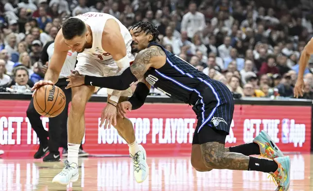 Cleveland Cavaliers' Max Strus, left, steals the ball from Orlando Magic's Gary Harris during the first half in Game 1 of an NBA basketball first-round playoff series, Saturday, April 20, 2024, in Cleveland. (AP Photo/Nick Cammett)