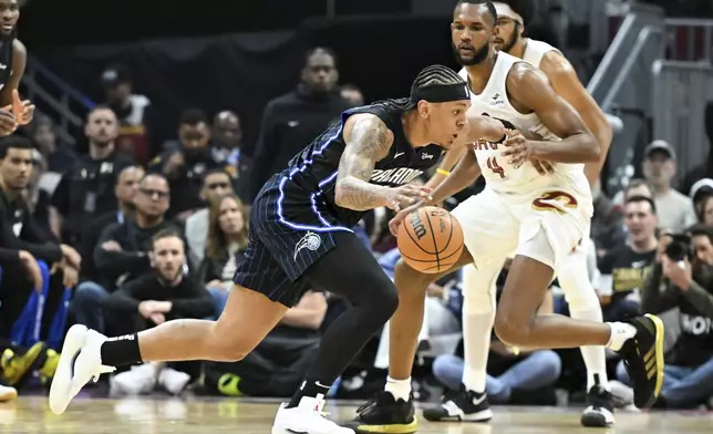 Orlando Magic's Paolo Banchero drives against Cleveland Cavaliers' Evan Mobley (4) during the first half in Game 1 of an NBA basketball first-round playoff series, Saturday, April 20, 2024, in Cleveland. (AP Photo/Nick Cammett)
