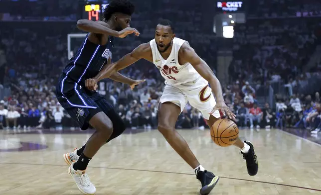 Cleveland Cavaliers forward Evan Mobley (4) drives against Orlando Magic forward Jonathan Isaac, left, during the first half of Game 2 of an NBA basketball first-round playoff series, Monday, April 22, 2024, in Cleveland. (AP Photo/Ron Schwane)