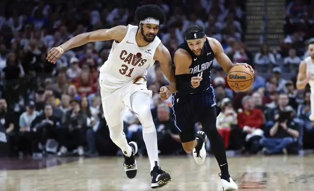 Orlando Magic guard Jalen Suggs, right, drives against Cleveland Cavaliers center Jarrett Allen (31) during the second half of Game 2 of an NBA basketball first-round playoff series, Monday, April 22, 2024, in Cleveland. (AP Photo/Ron Schwane)