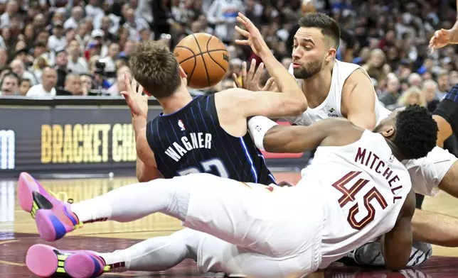 Cleveland Cavaliers' Max Strus (1) and Donovan Mitchell (45) fight for a loose ball with Orlando Magic's Franz Wagner (22) during the second half in Game 1 of an NBA basketball first-round playoff series, Saturday, April 20, 2024, in Cleveland. (AP Photo/Nick Cammett)