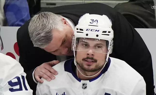 Toronto Maple Leafs head coach Sheldon Keefe speaks with Auston Matthews (34) during the third period of the team's NHL hockey game against the Tampa Bay Lightning on Wednesday, April 17, 2024, in Tampa, Fla. (Frank Gunn/The Canadian Press via AP)