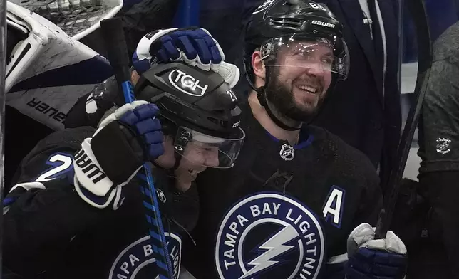 Tampa Bay Lightning right wing Nikita Kucherov, right, celebrates after assisting on a goal by center Brayden Point, left, during the second period of an NHL hockey game Wednesday, April 17, 2024, in Tampa, Fla. The assist was Kucherov's 100th of the season. (AP Photo/Chris O'Meara)