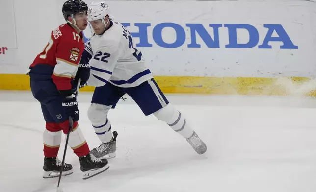 Toronto Maple Leafs defenseman Jake McCabe (22) slashes Florida Panthers center Evan Rodrigues (17) during the first period of an NHL hockey game, Tuesday, April 16, 2024, in Sunrise, Fla. (AP Photo/Wilfredo Lee)
