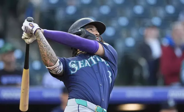 Seattle Mariners' J.P. Crawford follows the flight of his triple to drive in three runs off Colorado Rockies starting pitcher Peter Lambert in the second inning of the second game of a baseball doubleheader Sunday, April 21, 2024, in Denver. (AP Photo/David Zalubowski)