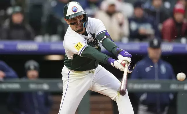 Colorado Rockies' Alan Trejo breaks his bat while grounding into a force play against Seattle Mariners starting pitcher Luis Castillo in the third inning of a baseball game Saturday, April 20, 2024, in Denver. (AP Photo/David Zalubowski)