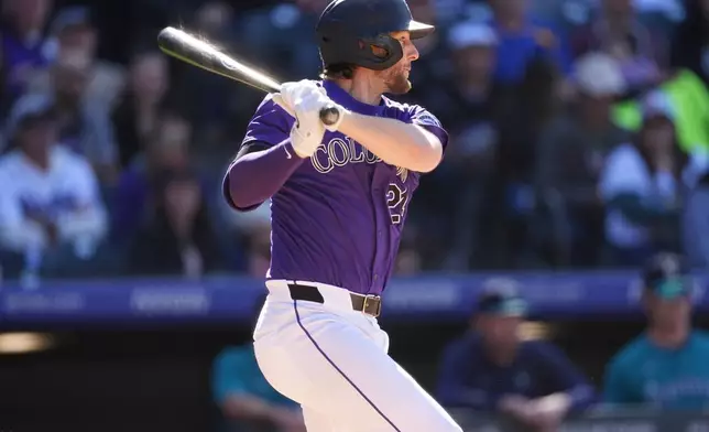 Colorado Rockies' Ryan McMahon follows the flight of his walk-off RBI single off Seattle Mariners pitcher Andrés Muñoz in the 10th inning of the first game of a baseball doubleheader Sunday, April 21, 2024, in Denver. (AP Photo/David Zalubowski)