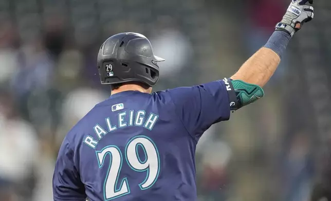 Seattle Mariners' Cal Raleigh gestures to the bullpen as he circles the bases after hitting a two-run home run off Colorado Rockies relief pitcher Noah Davis in the sixth inning of the second game of a baseball doubleheader Sunday, April 21, 2024, in Denver. (AP Photo/David Zalubowski)