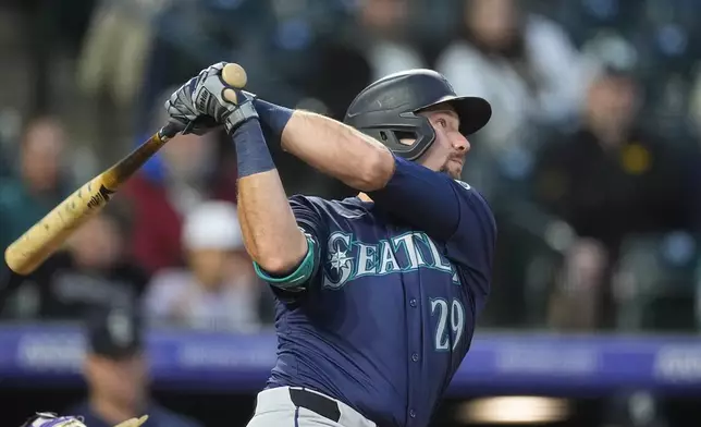 Seattle Mariners' Cal Raleigh follows the flight of his two-run home run off Colorado Rockies relief pitcher Noah Davis in the sixth inning of the second game of a baseball doubleheader Sunday, April 21, 2024, in Denver. (AP Photo/David Zalubowski)
