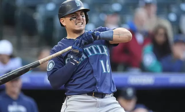 Seattle Mariners' Luis Urías reacts after getting hit on the hands by a pitch from Colorado Rockies starter Peter Lambert in the second inning of the second game of a baseball doubleheader Sunday, April 21, 2024, in Denver. (AP Photo/David Zalubowski)