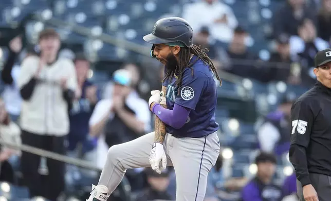 Seattle Mariners' J.P. Crawford, left, reacts after reaching third base on a triple that drove in three runs off Colorado Rockies starting pitcher Peter Lambert in the second inning of the second game of a baseball doubleheader Sunday, April 21, 2024, in Denver. (AP Photo/David Zalubowski)