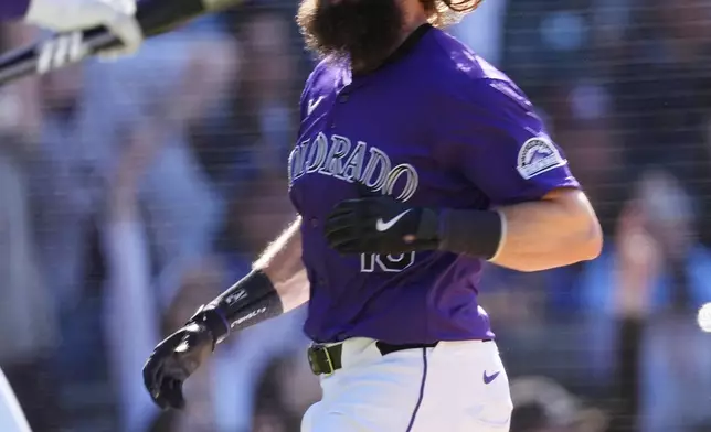 Colorado Rockies' Charlie Blackmon scores the winning run on a walk-off single by Ryan McMahon off Seattle Mariners relief pitcher Andrés Muñoz in the 10th inning of the first game of a baseball doubleheader Sunday, April 21, 2024, in Denver. (AP Photo/David Zalubowski)