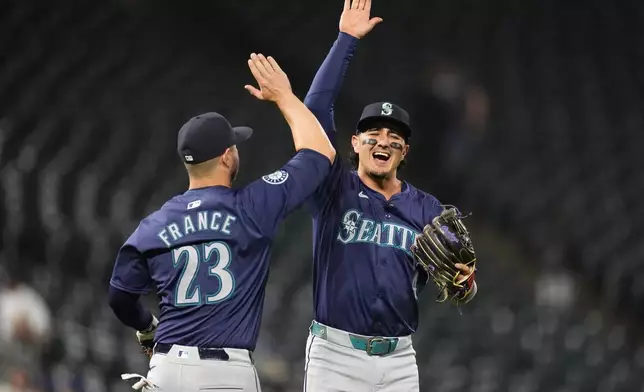 Seattle Mariners first base Ty France (23) congratulates Josh Rojas after the second game of a baseball doubleheader against the Colorado Rockies Sunday, April 21, 2024, in Denver. (AP Photo/David Zalubowski)