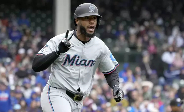 Miami Marlins' Bryan De La Cruz celebrates his two-run home run off Chicago Cubs relief pitcher Adbert Alzolay during the ninth inning in the first baseball game of a doubleheader, Saturday, April 20, 2024, in Chicago. The Marlins won 3-2. (AP Photo/Charles Rex Arbogast)
