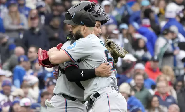 Miami Marlins relief pitcher Tanner Scott celebrates with catcher Jhonny Pereda after the team's 3-2 win over the Chicago Cubs in the first baseball game of a doubleheader, Saturday, April 20, 2024, in Chicago. (AP Photo/Charles Rex Arbogast)