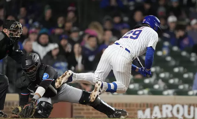 Chicago Cubs' Michael Busch avoids a wild pitch from Miami Marlins relief pitcher Anthony Bender during the sixth inning in the second baseball game of a doubleheader Saturday, April 20, 2024, in Chicago . (AP Photo/Charles Rex Arbogast)