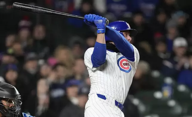 Chicago Cubs' Michael Busch follows through on a two-run single off Miami Marlins relief pitcher Anthony Bender during the sixth inning in the second baseball game of a doubleheader Saturday, April 20, 2024, in Chicago . (AP Photo/Charles Rex Arbogast)