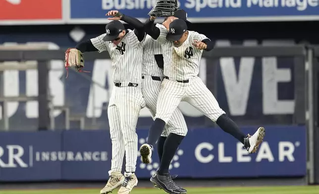 New York Yankees' Alex Verdugo, left, Aaron Judge, center, and Juan Soto celebrate after defeating the Miami Marlins in a baseball game, Tuesday, April 9, 2024, in New York. The Yankees won 3-2. (AP Photo/Mary Altaffer)
