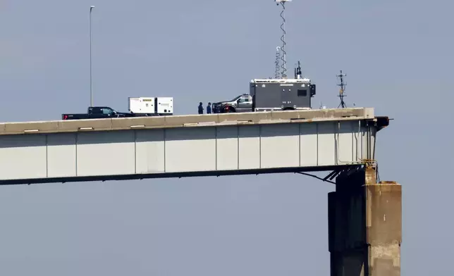People work on a standing section of the collapsed Francis Scott Key Bridge, Monday, April 15, 2024, in Baltimore. The FBI confirmed that agents were aboard the Dali conducting court-authorized law enforcement activity. (AP Photo/Julia Nikhinson)