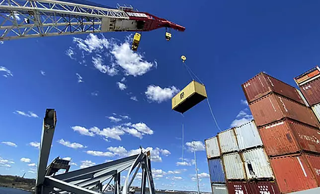 In this photo provided by the Key Bridge Response 2024 Unified Command, response crews begin removing shipping containers from the deck of the cargo ship Dali using a floating crane barge at the site of the Francis Scott Key Bridge, Sunday, April 7, 2024, in Baltimore. (Key Bridge Response 2024 Unified Command via AP)