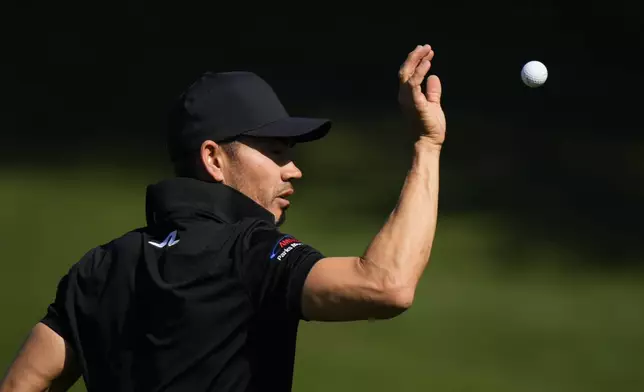 Camilo Villegas, of Colombia, catches a golf ball on the practice range during a practice round in preparation for the Masters golf tournament at Augusta National Golf Club Monday, April 8, 2024, in Augusta, Ga. (AP Photo/Matt Slocum)