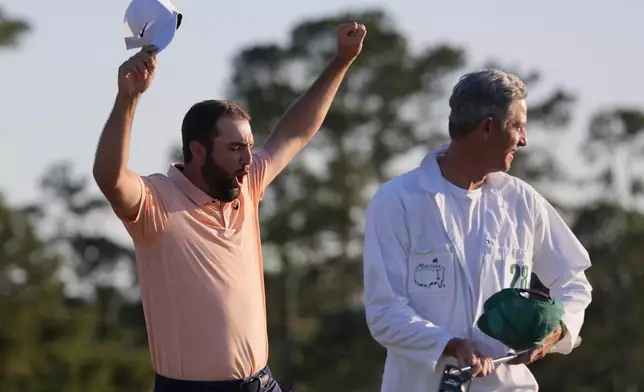 Scottie Scheffler celebrates with his caddie Ted Scott after winning the Masters golf tournament at Augusta National Golf Club Sunday, April 14, 2024, in Augusta, Ga. (AP Photo/David J. Phillip)