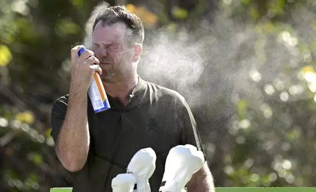 FILE - Mike Flaskey, CEO of Diamond Resorts International, sprays himself with sunscreen before hitting his tee shot on the second hole during the final round of the Tournament of Champions LPGA golf tournament, Sunday, Jan. 24, 2021, in Lake Buena Vista, Fla. (AP Photo/Phelan M. Ebenhack, File)