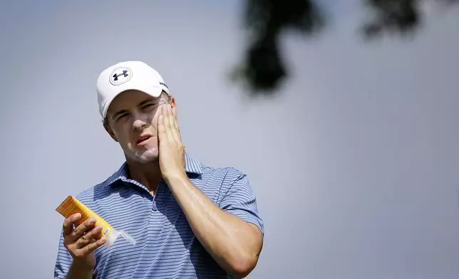 FILE - Jordan Spieth applies sunscreen during the first round of the SMBC Singapore Open golf tournament at the Sentosa Golf Club's Serapong Course Thursday, Jan. 28, 2016, in Singapore. Golfers are in the sun as much if not more than players in other sport. It can be as many as eight hours a day. And there is renewed emphasis on protecting their skin. (AP Photo/Wong Maye-E, File)