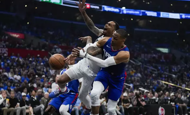 LA Clippers guard Russell Westbrook, right, fouls Dallas Mavericks forward P.J. Washington (25) during the first half of Game 1 of an NBA basketball first-round playoff series in Los Angeles, Sunday, April 21, 2024. (AP Photo/Ashley Landis)
