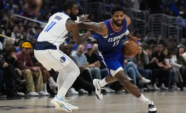 Dallas Mavericks guard Kyrie Irving (11) defends against LA Clippers forward Paul George (13) during the first half of Game 1 of an NBA basketball first-round playoff series in Los Angeles, Sunday, April 21, 2024. (AP Photo/Ashley Landis)