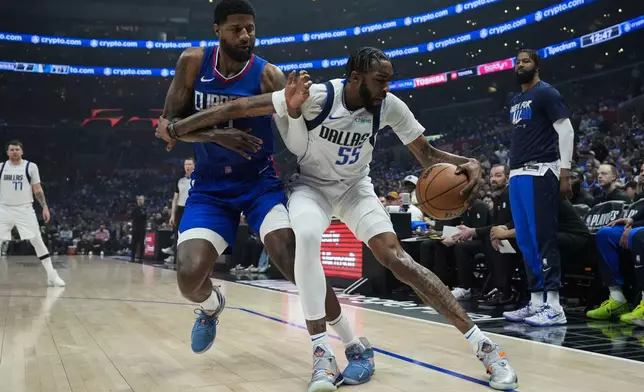 LA Clippers forward Paul George (13) defends against Dallas Mavericks forward Derrick Jones Jr. (55) during the first half of Game 1 of an NBA basketball first-round playoff series in Los Angeles, Sunday, April 21, 2024. (AP Photo/Ashley Landis)