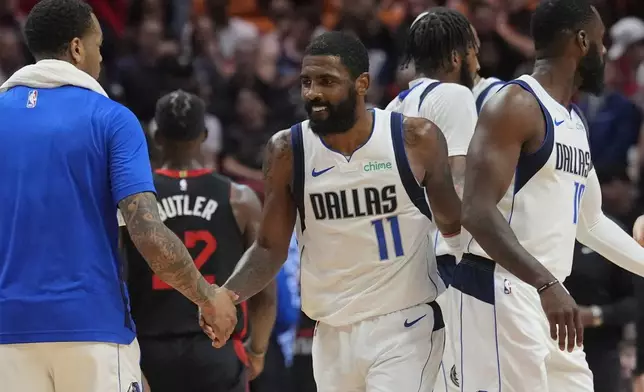 Dallas Mavericks guard Kyrie Irving (11) shakes hands with his teammates during the first half of an NBA basketball game against the Miami Heat, Wednesday, April 10, 2024, in Miami. (AP Photo/Marta Lavandier)