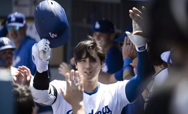 Los Angeles Dodgers' Shohei Ohtani celebrates after his two-run home run in the dugout during the third inning of a baseball game against the New York Mets in Los Angeles, Sunday, April 21, 2024. (AP Photo/Kyusung Gong)