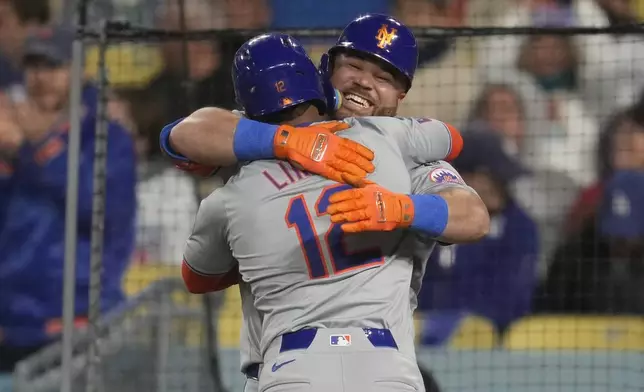 New York Mets' Francisco Lindor (12) celebrates with designated hitter DJ Stewart after hitting a home run during the seventh inning of a baseball game against the Los Angeles Dodgers in Los Angeles, Friday, April 19, 2024. Starling Marte also scored. (AP Photo/Ashley Landis)