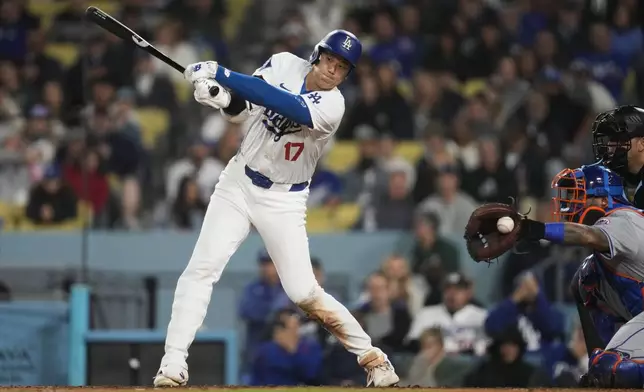 Los Angeles Dodgers designated hitter Shohei Ohtani (17) swings a strike during the seventh inning of a baseball game against the New York Mets in Los Angeles, Friday, April 19, 2024. (AP Photo/Ashley Landis)