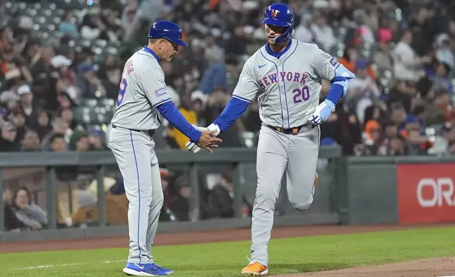New York Mets' Pete Alonso (20) is congratulated by third base coach Mike Sarbaugh after hitting a home run against the San Francisco Giants during the fifth inning of a baseball game in San Francisco, Monday, April 22, 2024. (AP Photo/Jeff Chiu)