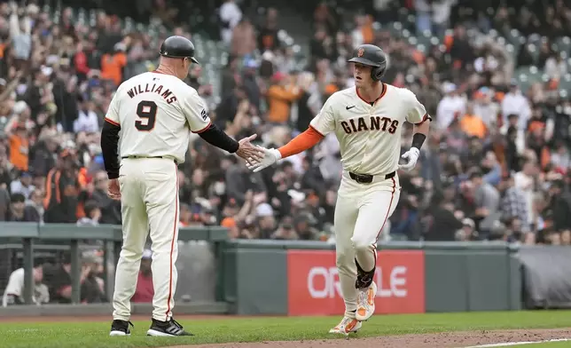 San Francisco Giants' Tyler Fitzgerald, right, is congratulated by third base coach Matt Williams (9) after hitting a home run during the seventh inning of a baseball game against the New York Mets in San Francisco, Wednesday, April 24, 2024. (AP Photo/Jeff Chiu)