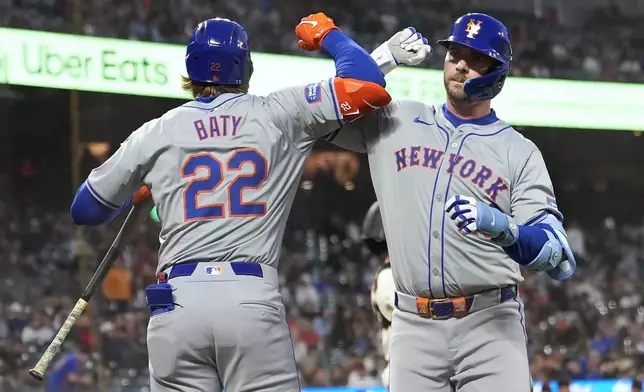 New York Mets' Pete Alonso, right, is congratulated by Brett Baty (22) after hitting a home run against the San Francisco Giants during the fifth inning of a baseball game in San Francisco, Monday, April 22, 2024. (AP Photo/Jeff Chiu)