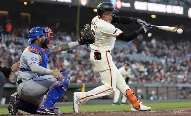 San Francisco Giants' Nick Ahmed, right, hits a two-run single in front of New York Mets catcher Omar Narváez during the second inning of a baseball game in San Francisco, Monday, April 22, 2024. (AP Photo/Jeff Chiu)