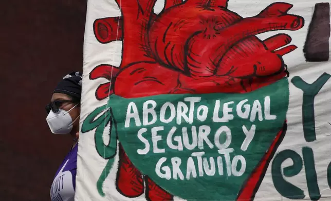 FILE - A woman holds a banner reading in Spanish, "Legal, safe, and free abortion" as abortion rights protesters demonstrate in front of the National Congress on the "Day for Decriminalization of Abortion in Latin America and the Caribbean," in Mexico City, Sept. 28, 2020. Mexico’s Supreme Court ruled in 2023 that national laws prohibiting abortions are unconstitutional and violate women’s rights. (AP Photo/Rebecca Blackwell, File)