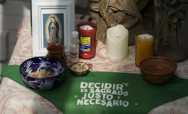 FILE - A green scarf with a message that reads in Spanish: "To decide is sacred, just and necessary" adorns an altar to Our Lady of Guadalupe, in the office of the Catholics for the Right to Decide, in Mexico City, Dec. 4, 2023. Members of the organization denounce the invisibility of women in some religious environments and advocate for the reinterpretation of sacred texts with a feminist perspective. (AP Photo/Eduardo Verdugo, File)