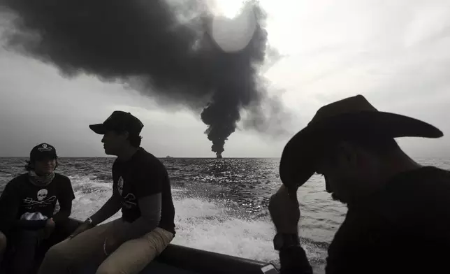 FILE - Members of the marine wildlife conservation organization Sea Shepherd monitor the fuel tanker Burgos, as it continues to burn a day after it erupted in flames off the coast of the port city of Boca del Rio, Mexico, Sept. 25, 2016. Mexico is committed to having 43% of the energy it generates come from non-contaminating sources by 2030. (AP Photo/Felix Marquez, File)