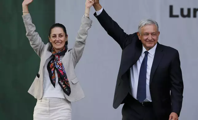 FILE - Mexico's President Andres Manuel Lopez Obrador, right, and Mayor Claudia Sheinbaum, greet supporters at a rally in Mexico City's main square, the Zocalo, July 1, 2019. Obrador led a fight against energy reforms that were aimed at drawing private investment to the massive state-run oil company, Pemex, and in 2024, the frontrunner in the race to replace him, Sheinbaum, chose the anniversary of Mexico's oil expropriation to announce her energy proposals. (AP Photo/Fernando Llano, File)