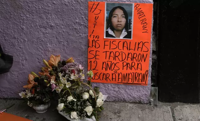 A basket of flowers sits next to a poster of Amarirany Roblero who went missing 12 years ago, during a protest outside an apartment rented by a suspected serial killer where evidence related to Roblero was found, in the Iztacalco neighborhood of Mexico City, Friday, April 26, 2024. (AP Photo/Marco Ugarte)